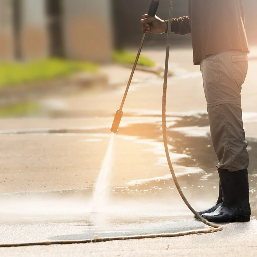 College Bros pressure washing a concrete driveway in the Monroe, LA area, restoring the original surface color