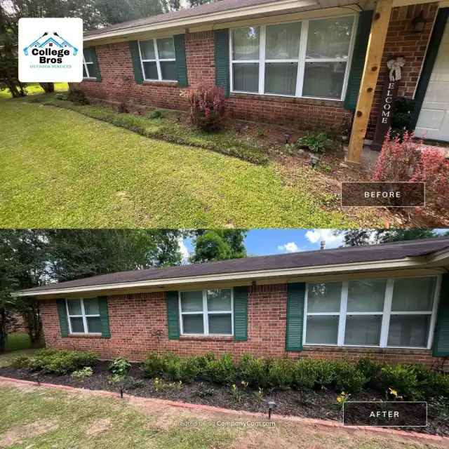 Freshly planted bed with flowers and landscape lights along a brick home with green shutters