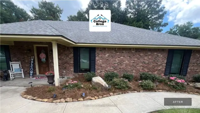 Landscape bed with boulder accents, stone edging, and blooming color beside a welcoming front porch