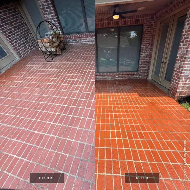 Half-cleaned brick wall showing vivid orange-red brick and white mortar beside the grimy unwashed side